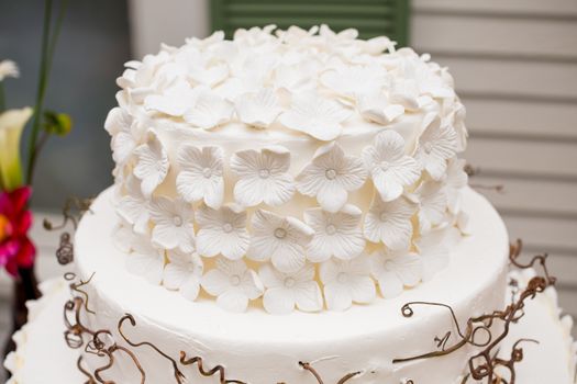 A beautiful wedding cake is set up at the reception for a bride and groom.