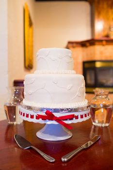 A beautiful wedding cake is set up at the reception for a bride and groom.