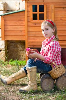 breeder hens kid girl rancher blond farmer playing with chicks in chicken tractor coop