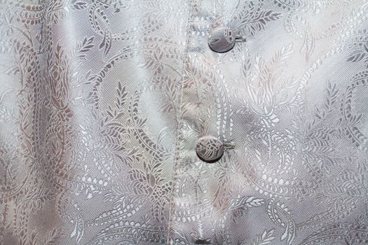 A closeup image of the vest for a tuxedo that a groomsmen is wearing on a wedding day.