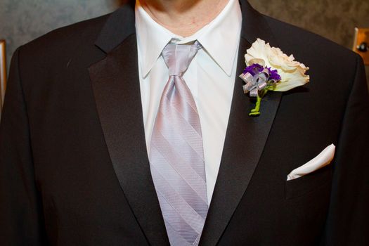 A groom wearing a fancy tuxedo on his wedding day ready to get hitched.