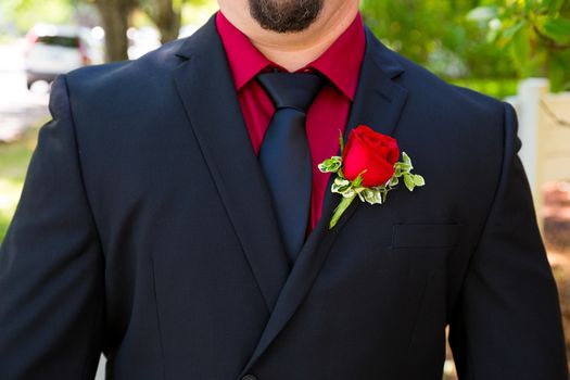 A groom wearing a fancy tuxedo on his wedding day ready to get hitched.