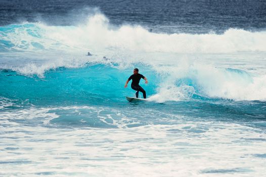 Surfer riding on a large wave on the Atlantic Coast. Canary island, Spain