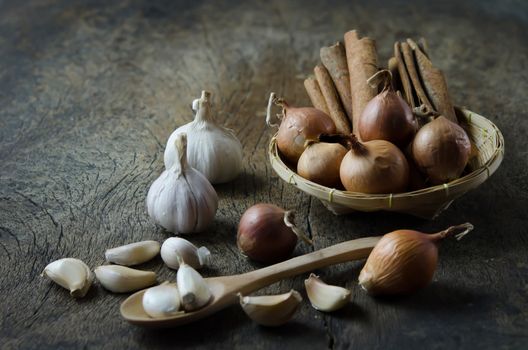 garlic , onion and cinnamon on  wooden board ( food ingredients )