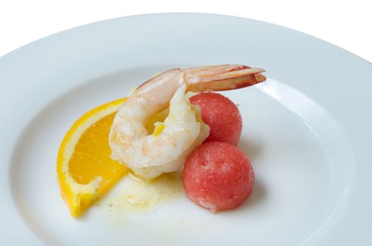 close up boiled shrimp , slices of orange and watermelon on dish over white background