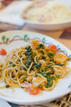 close up stir fried spicy spaghetti with shrimp and mix asian herbs , mix vegetable