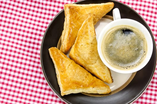 hot coffee in white cup  and puff pastry  on dish 