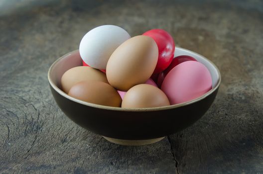 colorful of  eggs in  bowl on wooden background