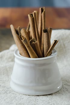 White  bowl with cinnamon sticks on  sackcloth
