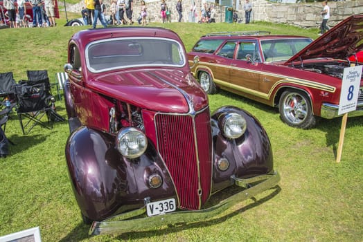 The image is shot at Fredriksten fortress in Halden, Norway during the annual classic car event.