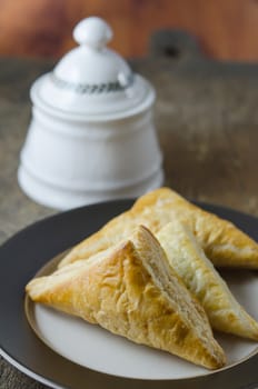 close up puff pastry on the plate over wooden background , sweet bread