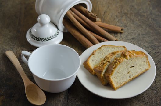  slices of banana cake on dish , cinnamon sticks  and empty cup with spoon