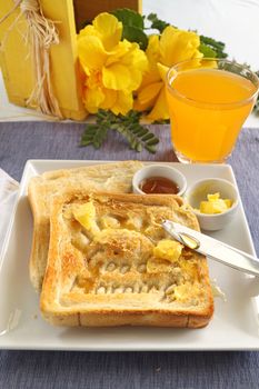 Slice of toast with Good Morning carved into it with butter and honey.