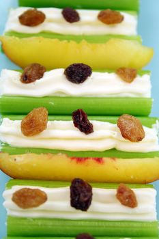 Healthy afternoon snack of celery sticks with cream cheese and sultanas.