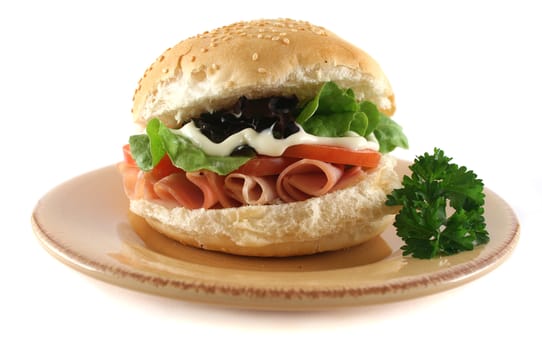Freshly prepared ham and salad roll with mayo.