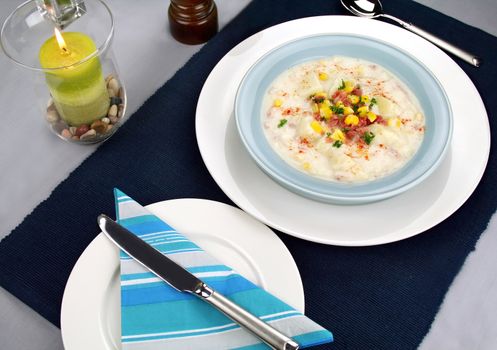Freshly prepared ham corn and potato chowder with paprika ready to serve.