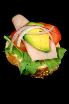 A delightful ham, tomato and avocado bite ready to eat.