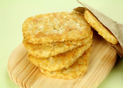 Stack of fried hash browns on a board ready to serve.