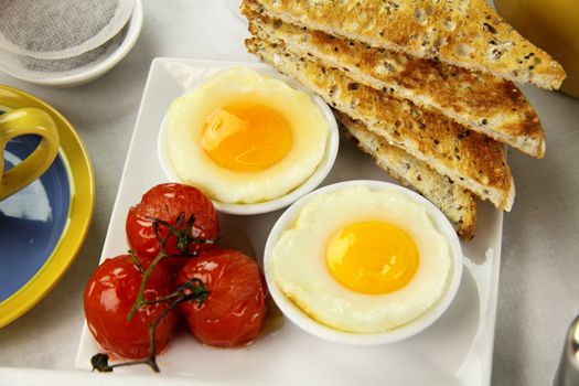 Delicious poached eggs and grilled tomatoes with toast.