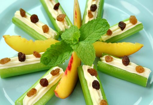 Healthy afternoon snack of celery sticks with cream cheese and sultanas.