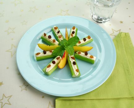Healthy afternoon snack of celery sticks with cream cheese and sultanas.