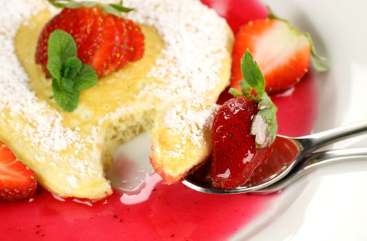 Heart shaped pancake with a spoonful taken out of it.
