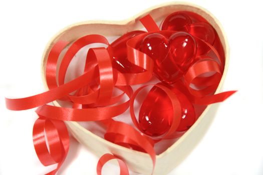 Red hearts and ribbons in a heart shaped box.