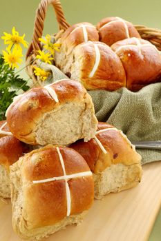 Hot cross buns in a basket with daisies ready to serve.