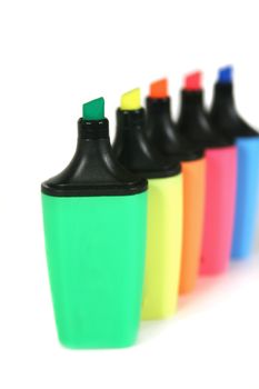 Multi colored highlighter pens in a row.