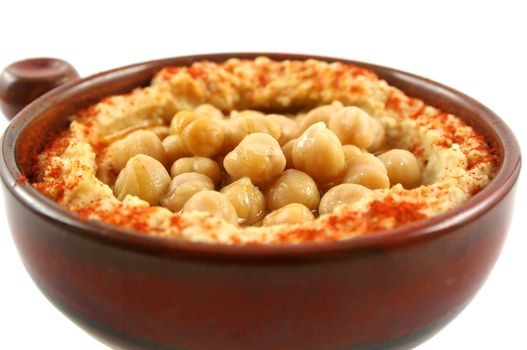 Earthenware bowl with delicious hommus and chickpeas ready for dipping.