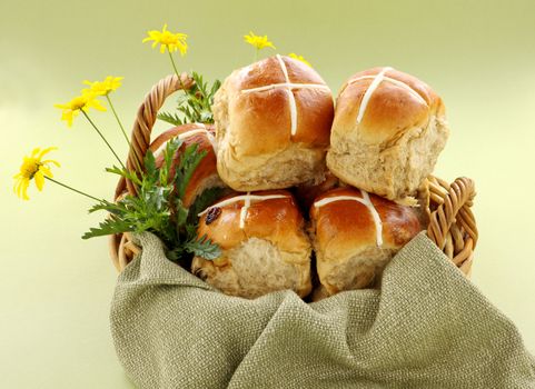 Hot cross buns in a basket with daisies ready to serve.