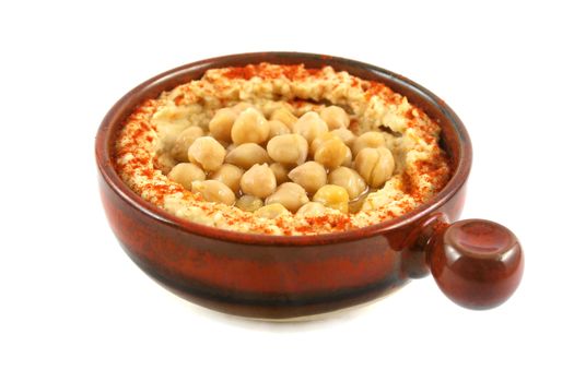 Earthenware bowl with delicious hommus and chickpeas ready for dipping.