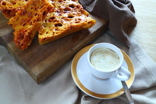 Delightful fresh baked crisp and crunchy sweet honeycomb dessert with coffee.