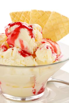 Vanilla ice cream with strawberry topping and golden wafers.