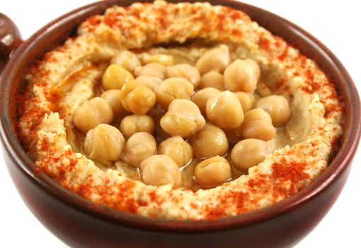 Earthenware bowl with delicious hommus and chickpeas ready for dipping.