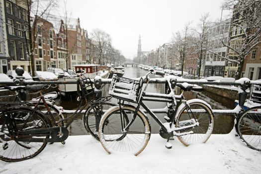 Amsterdam covered with snow with the Westerkerk in winter in the Netherlands