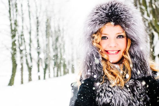 Woman is walking in park alley in winter