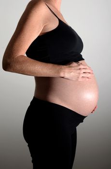 pregnant woman or expectant mother with hands on stomach