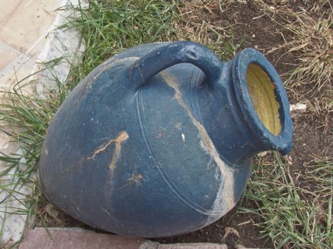 blue clay jug lying on the grass as a decor beds