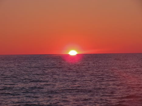  crimson sunset on a background of the dark blue sea                              