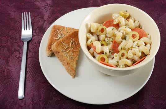 creamy pasta with pepperoni and olives with rosemary garlic bread