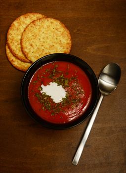 warm tomato soup on a dark wooden table for an autumn meal