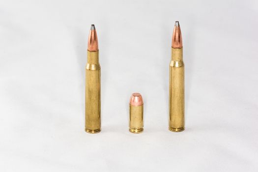 A few rifle and hand gun bullets on white background with details