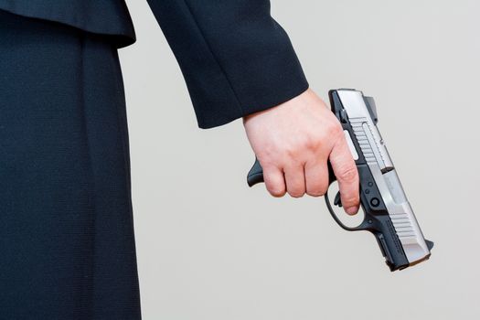 Close up of a the back side of a woman in business suit holding a hand gun