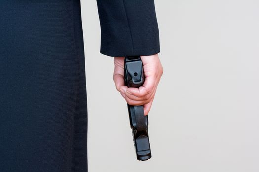 Close up of a the back side of a woman in business suit holding a hand gun