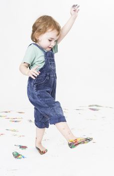 young child with paint on feet walking around