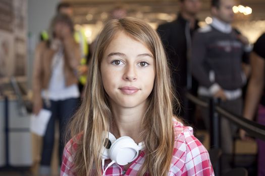 A young woman sitting in an airport lounge, waiting to board a plane