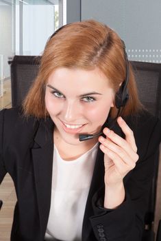 Businesswoman sit at desk and talking on headset 