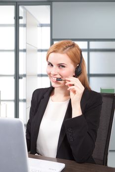 Businesswoman sit at desk and talking on headset 