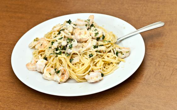 A delicious shrimp scampi pasta dish with calamari parsley garlic and olive oil. Shallow depth of field.